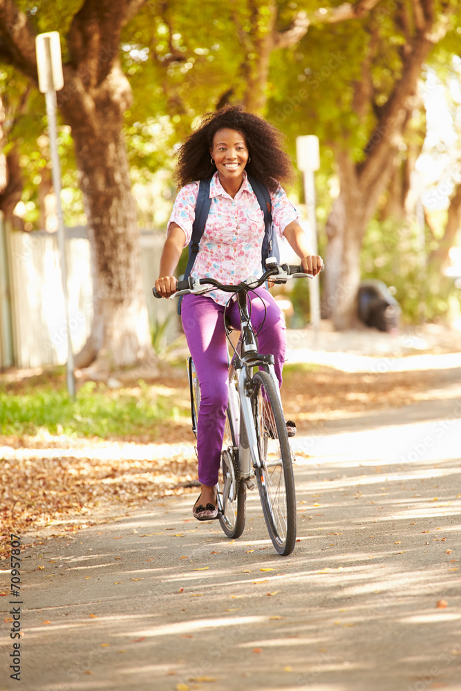Fototapeta premium Young Woman Cycling Along Street To Work