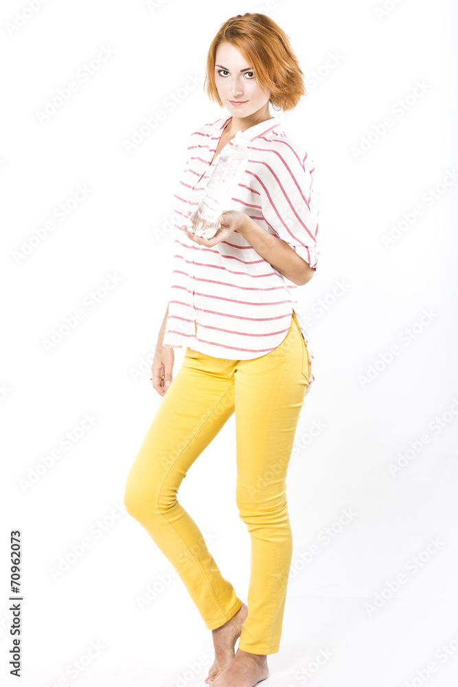 Young slim woman drinks mineral water from a bottle Young slim woman drinks mineral water from a bottle