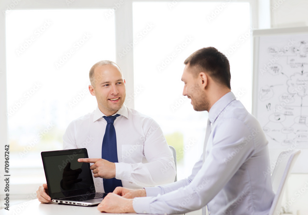 two smiling businessmen with laptop in office two smiling businessmen with laptop in office