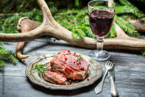 Red wine in a glass and venison on a plate