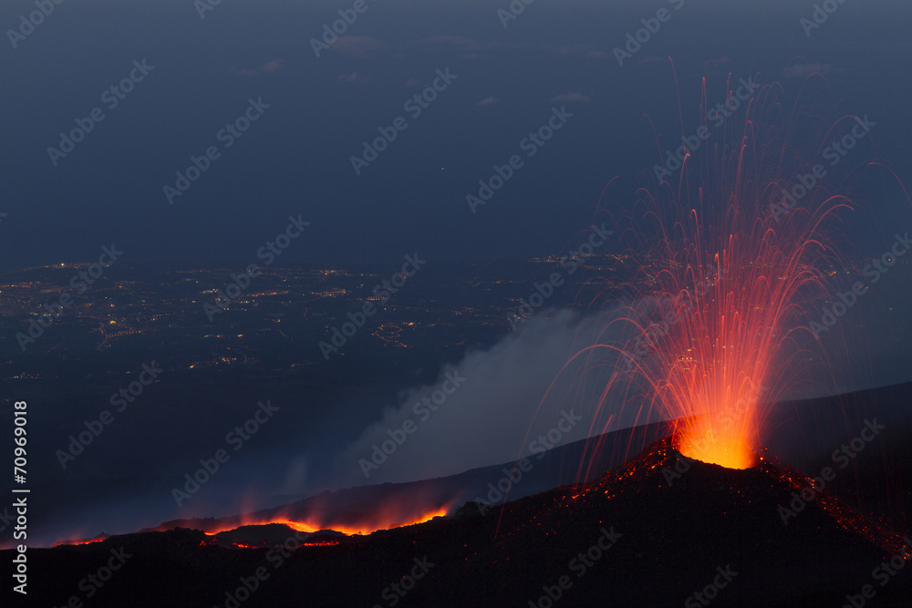 Etna eruption at sunset with cityscape background