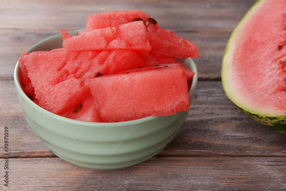 Slice of watermelon in bowl on wooden table Slice of watermelon in bowl on wooden table