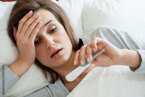 Woman with fever in bed photo