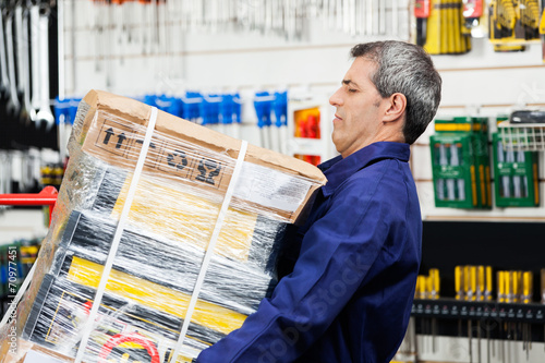 Tablou pe pânză Worker Lifting Heavy Tool Package In Hardware Shop