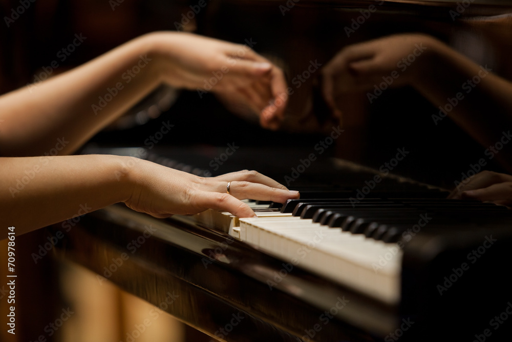 Woman's hands on the keyboard of the piano closeup Woman's hands on the keyboard of the piano closeup