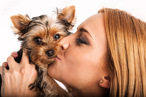 Beautiful blonde woman kissing yorkshire terrier - close up