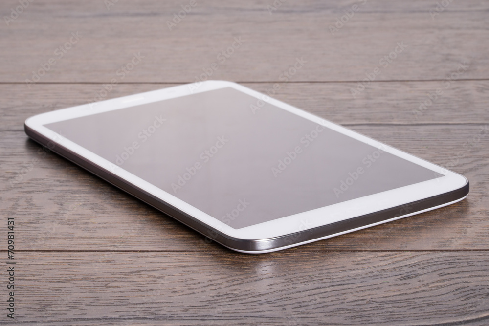 Modern tablet on wooden table Modern tablet on wooden table