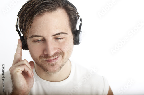 Attractive man with headphones in front of a white background en