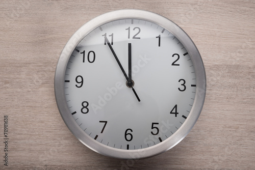 Clock showing five before noon