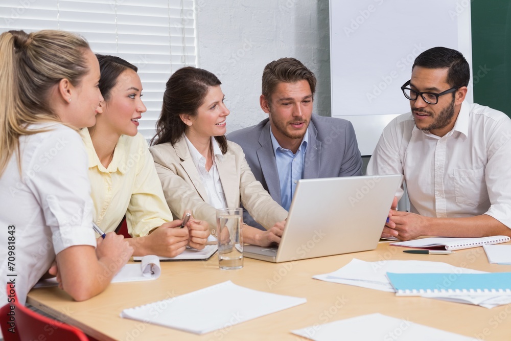 Casual business team having a meeting using laptop