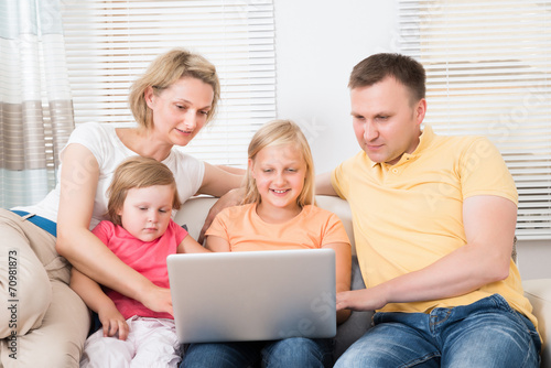 Family Using Laptop On Sofa