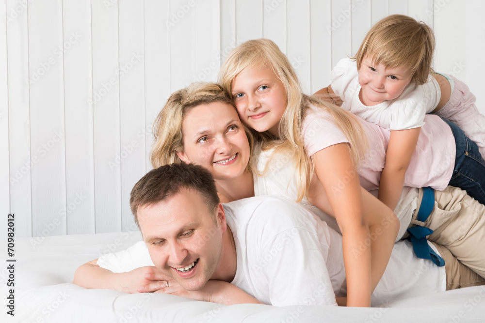 Young Family Lying Together In Bed