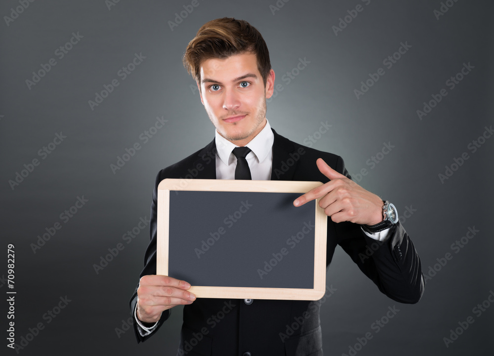 Confident Businessman Pointing At Blank Slate