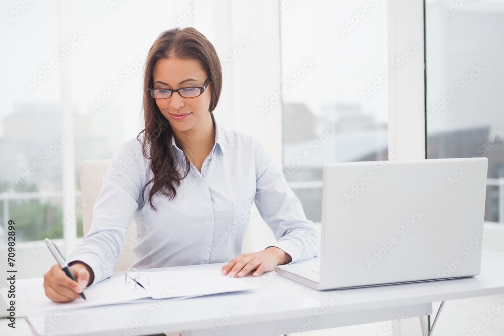 Smiling businesswoman working at her desk Smiling businesswoman working at her desk