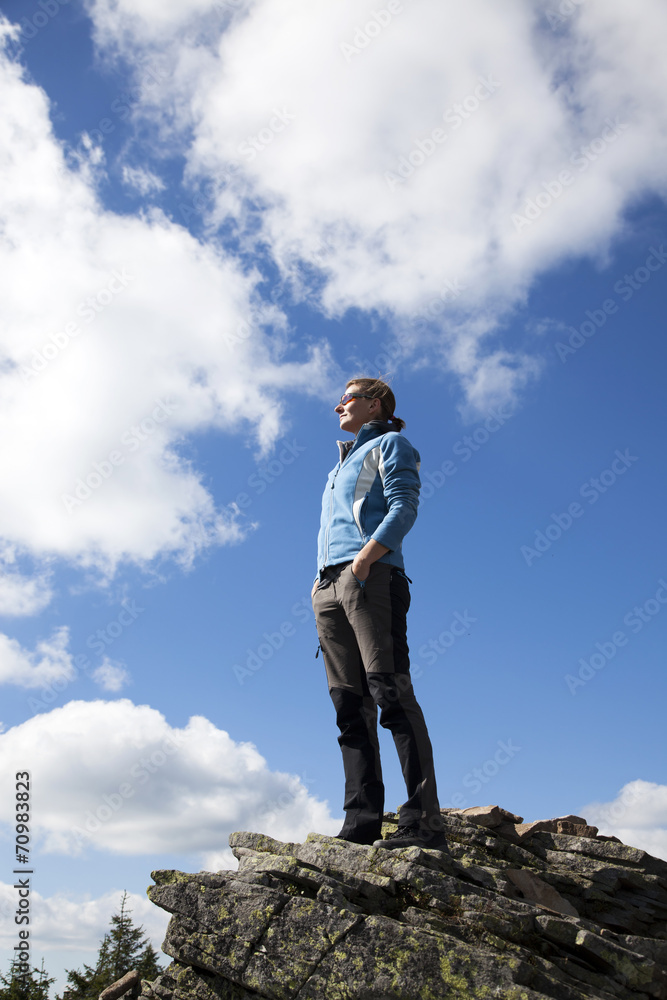 Woman on a cliff enjoying nature after a trek Woman on a cliff enjoying nature after a trek