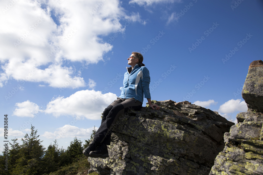 Woman on a cliff enjoying nature after a trek