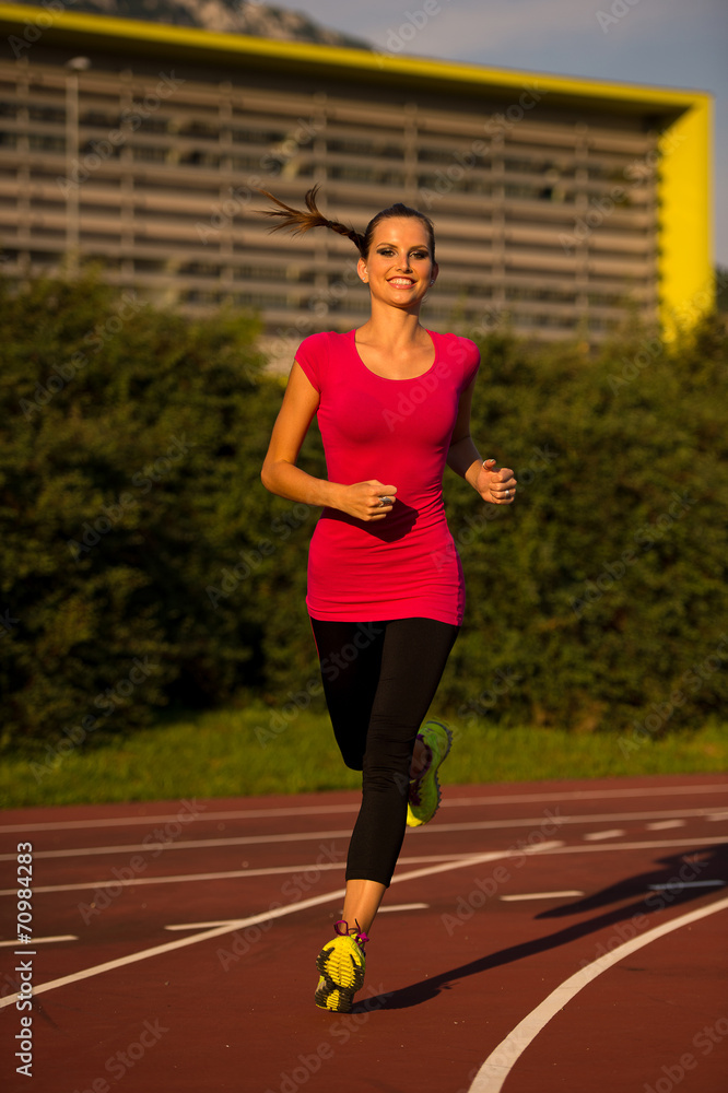 Preety young woman running on a track