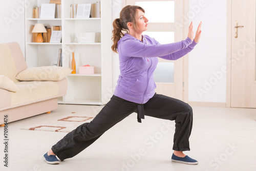 Woman doing qi gong tai chi exercise photo