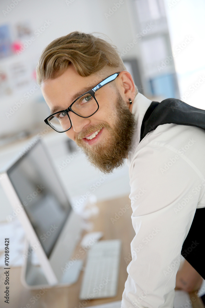 Young man with beard and eyeglasses in office Young man with beard and eyeglasses in office
