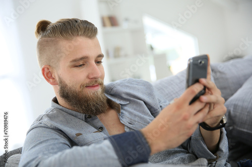 Young man sending text message with smartphone