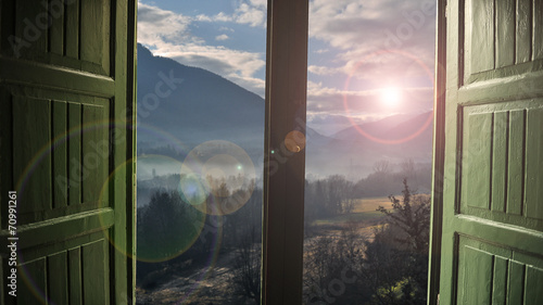Open window with countryside view and sunlight streaming in photo