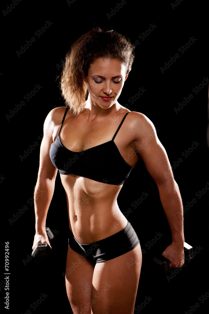 Sporty muscular woman with two dumbbells