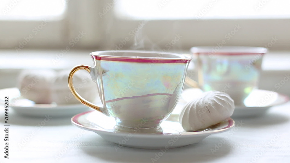 Two cups of hot tea and dessert on the table