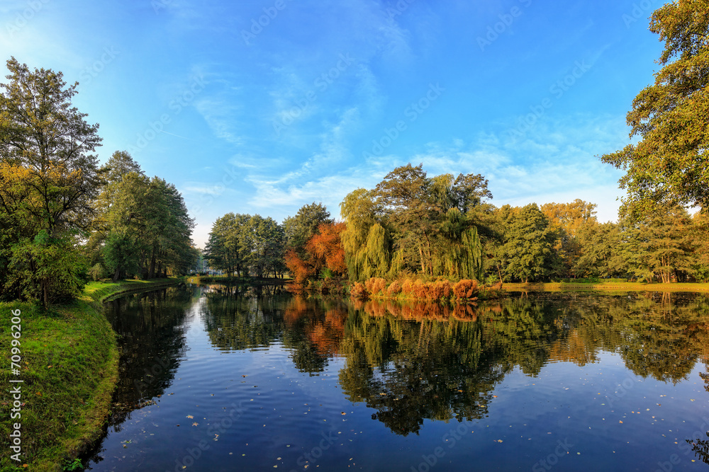 Pond in the autumn park with small island in background