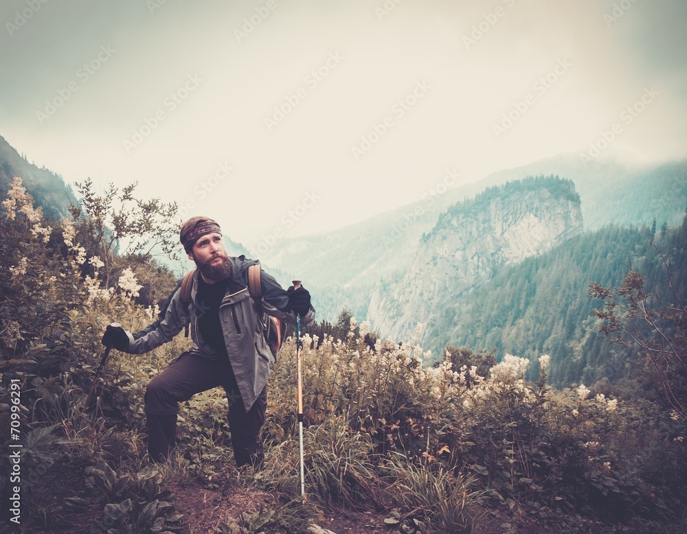 Man with hiking equipment walking in mountain forest