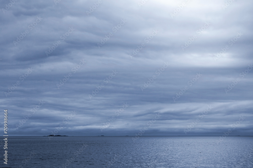 Dark blue stormy cloudy sky. Empty Norwegian Sea landscape backg