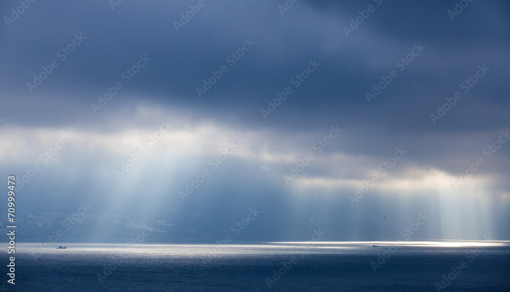 Sunlight goes through dark clouds. Bay of Tangier, Morocco Sunlight goes through dark clouds. Bay of Tangier, Morocco