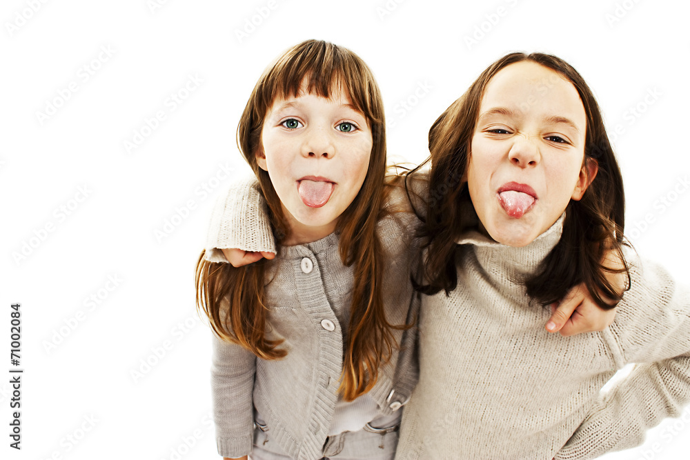 Two girls showing their tongues on white background Two girls showing their tongues on white background