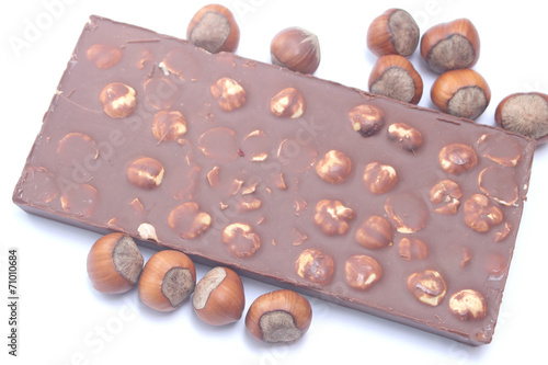 Chocolate bar with hazelnuts on white background