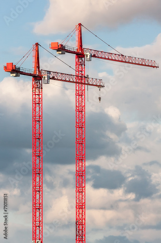 Two red crane on the sky background
