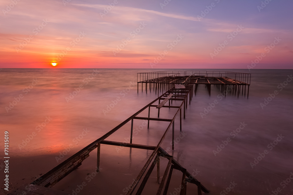 Beautiful sunrise landscape with a pier on background. Long expo