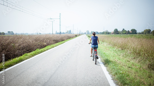 girl cycling on deserted road