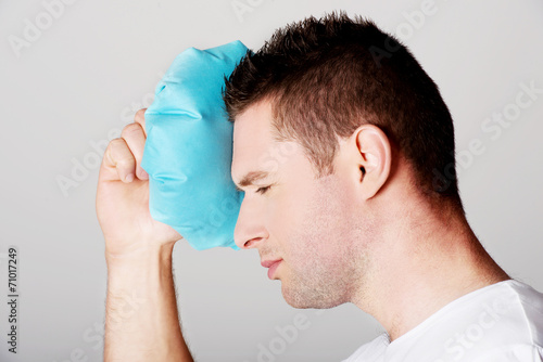 Man with ice bag for headaches