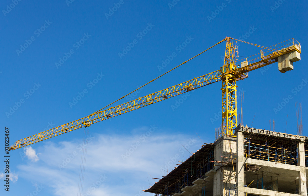 Tower Crane and Skyscraper on Blue Sky Background