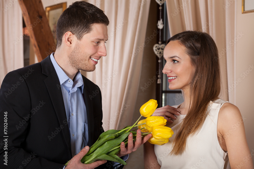 Young man giving flowers - obrazy, fototapety, plakaty 