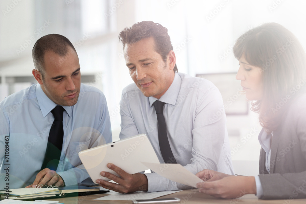 Business people meeting around desk with tablet Business people meeting around desk with tablet