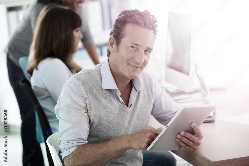Attractive businessman in office using tablet Attractive businessman in office using tablet