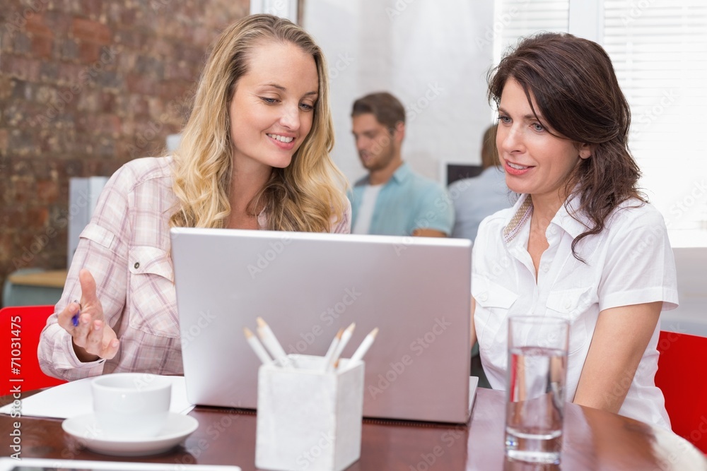 Happy businesswomen looking at computer screen together Happy businesswomen looking at computer screen together