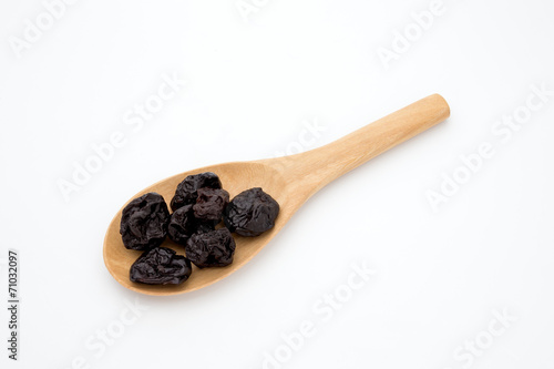 Plum in a wood spoon