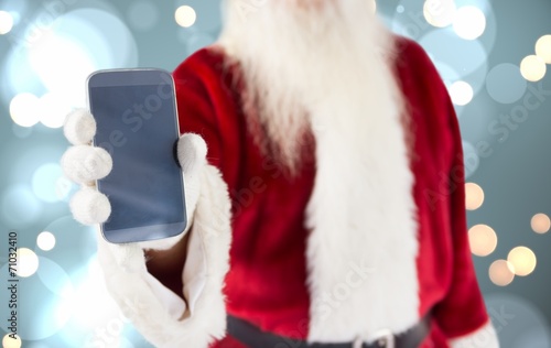 Composite image of santa claus showing smartphone