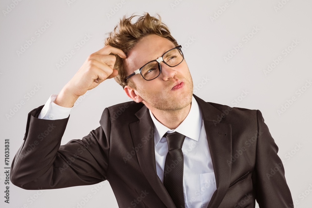 Young geeky businessman scratching his head Young geeky businessman scratching his head