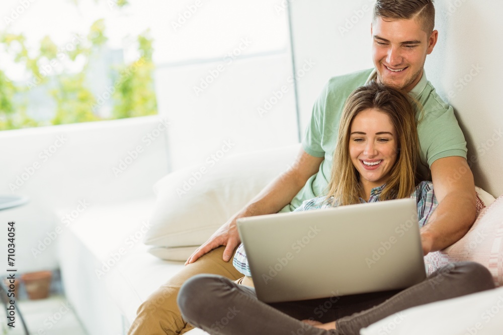 Cute couple relaxing on couch with laptop Cute couple relaxing on couch with laptop