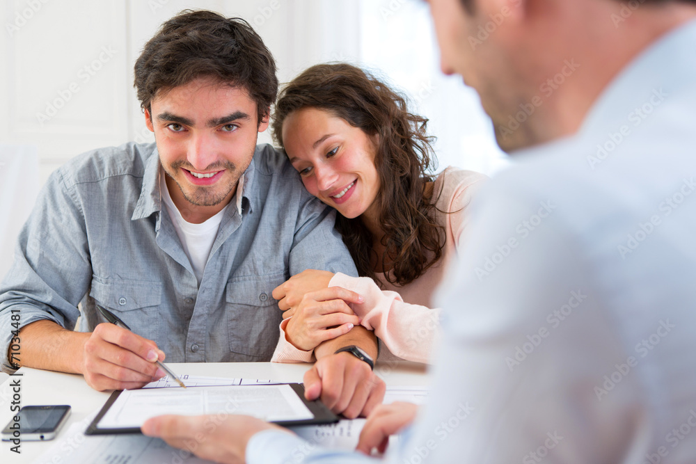 Young attractive couple signing contract Young attractive couple signing contract