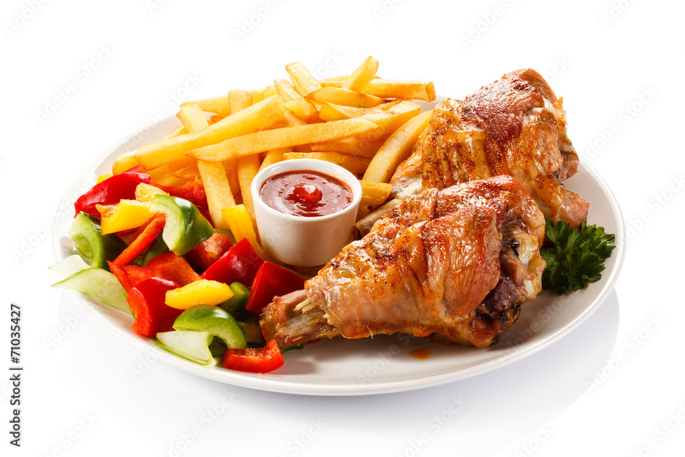 Grilled turkey legs with French fries and vegetables Grilled turkey legs with French fries and vegetables
