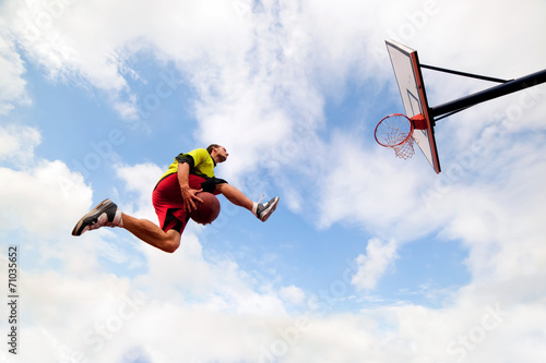Young man making a slam dunk playing streetball basketball © Photocreo Bednarek