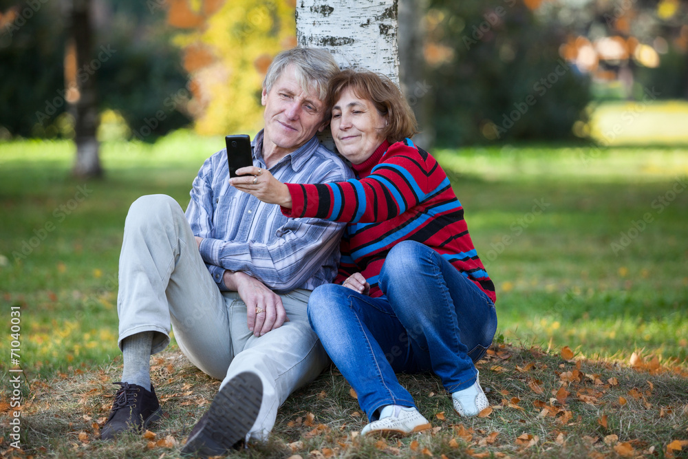 Mature Caucasian pair making selfie with cellphone at autumn Mature Caucasian pair making selfie with cellphone at autumn